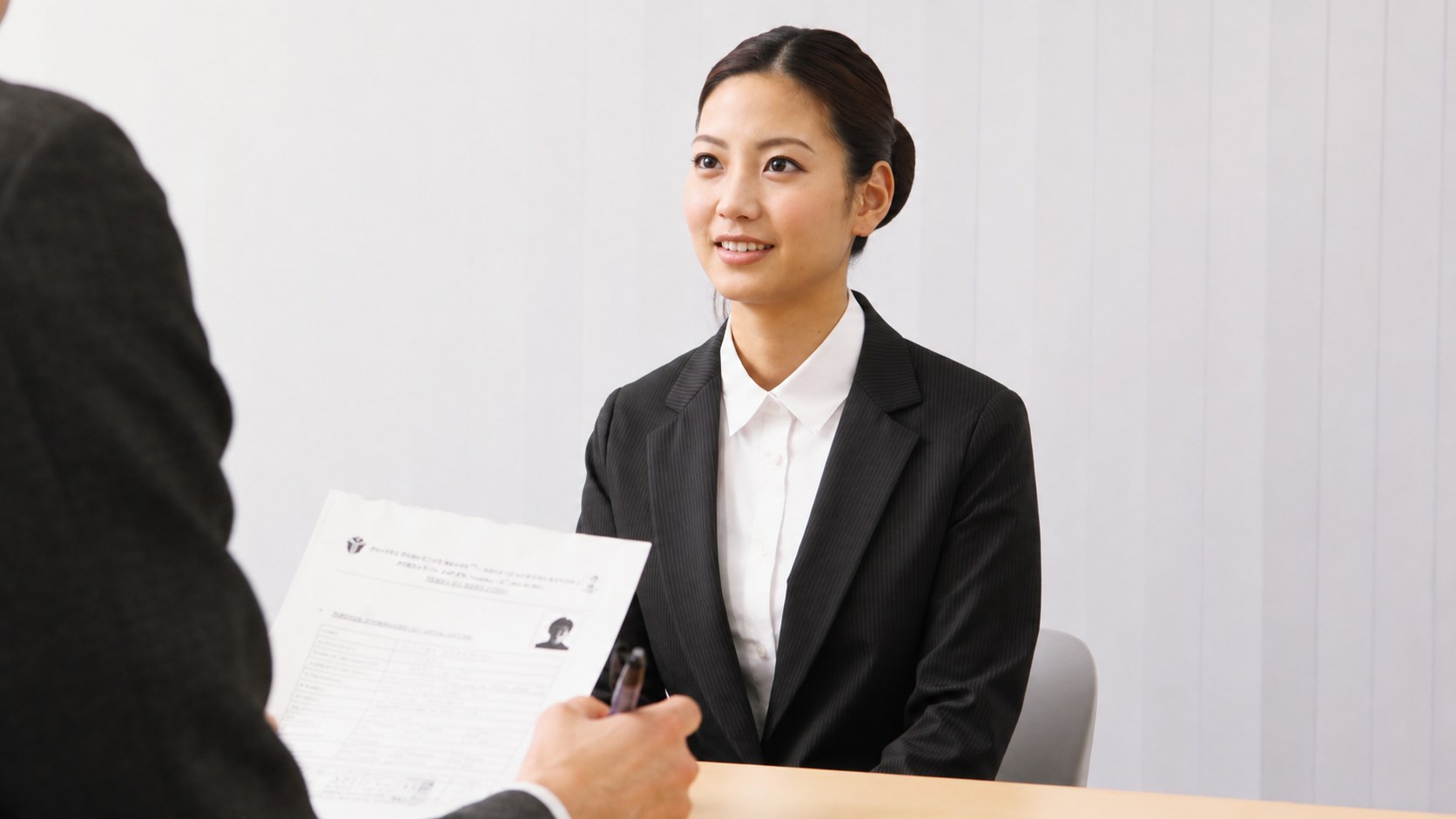 Candidate in a one-on-one interview, interviewer reviewing her CV